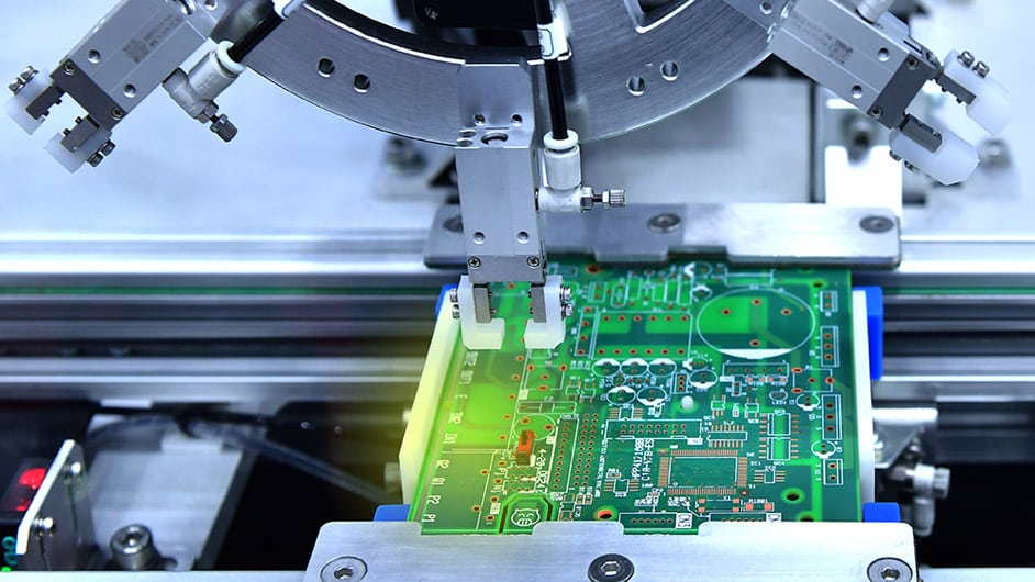 Une carte de circuit imprimé est produite par une machine robotisée.