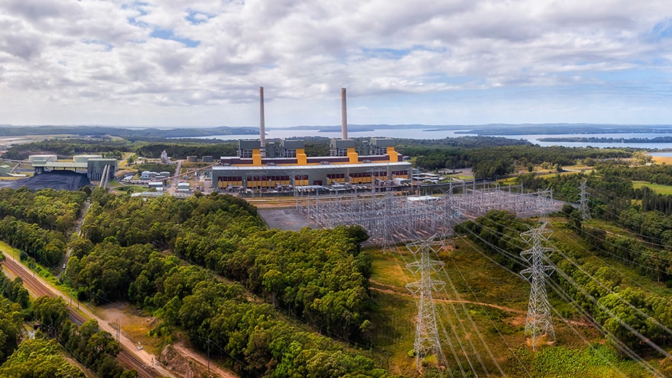 Una vista aérea muestra 4 torres y docenas de líneas de transmisión de energía que van directamente a una planta de generación de energía.
