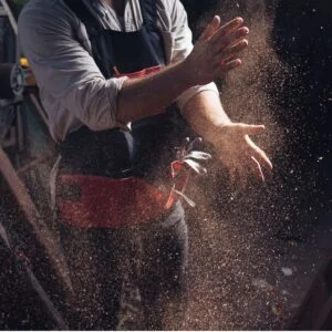 Woodworker dispersing dust particles in air, emphasizing airborne wood dust hazards
